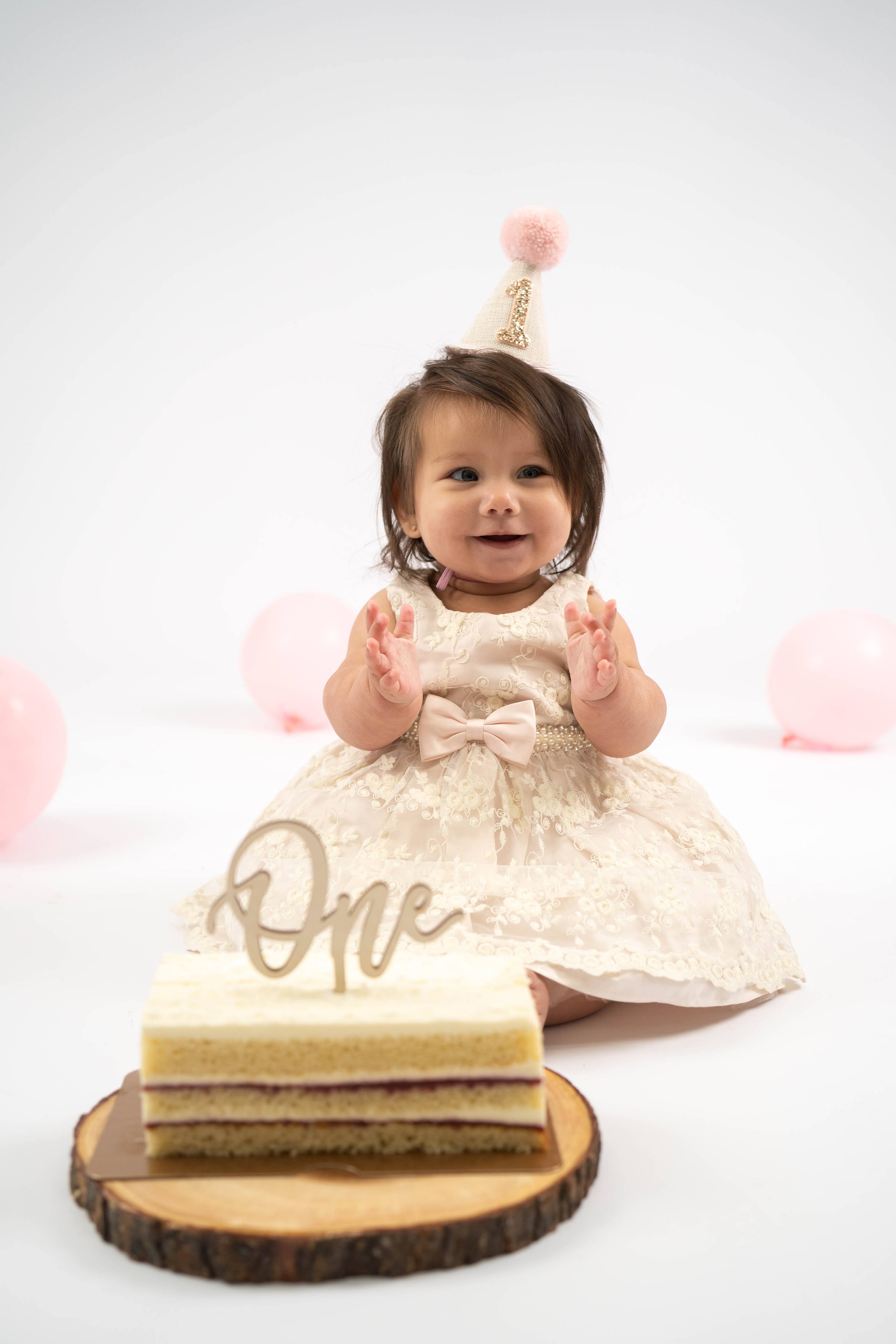 One-year-old sitting in a simple birthday setup during a Solano County cake smash session.