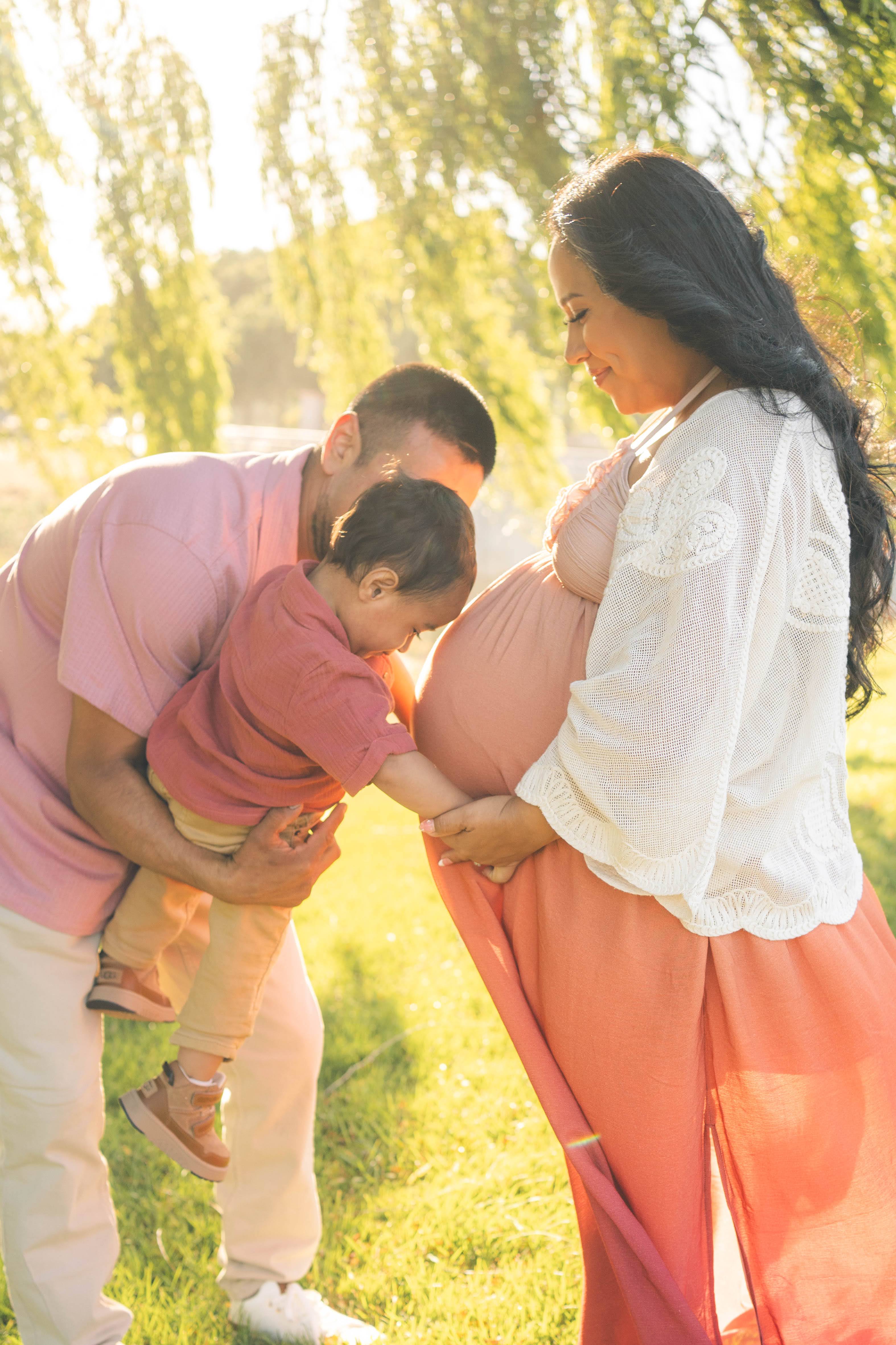 Expecting mother looking down at her bump during a soft maternity photography session.